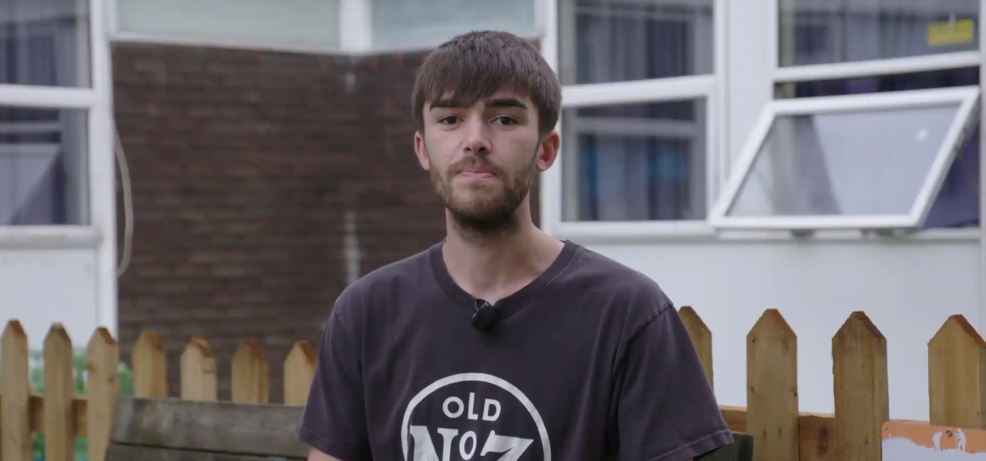 young man standing outside hostel